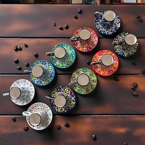 May include: A collection of colorful, patterned ceramic coffee cups and saucers. The cups and saucers feature intricate floral designs in various colors, including blue, red, green, and white. The arrangement is on a dark wooden surface with scattered coffee beans.