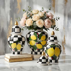 Puede incluir: Conjunto de jarrones decorativos de cerámica con diseños de cuadros blancos y negros. Los jarrones presentan limones amarillos pintados a mano con hojas verdes y detalles rojos. Los jarrones están rematados con remates dorados y contienen un ramo de rosas.