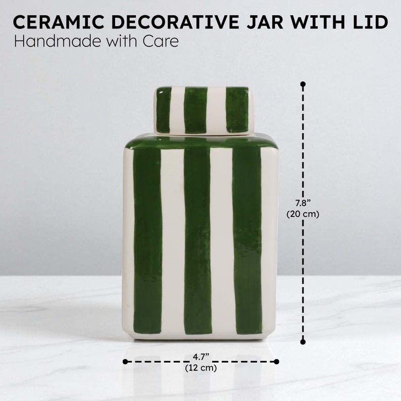 Pu&ograve; includere: Vaso decorativo in ceramica con coperchio, fatto a mano. Il vaso bianco presenta strisce verticali verdi e un coperchio abbinato. Misura 12 cm di larghezza e 20 cm di altezza.