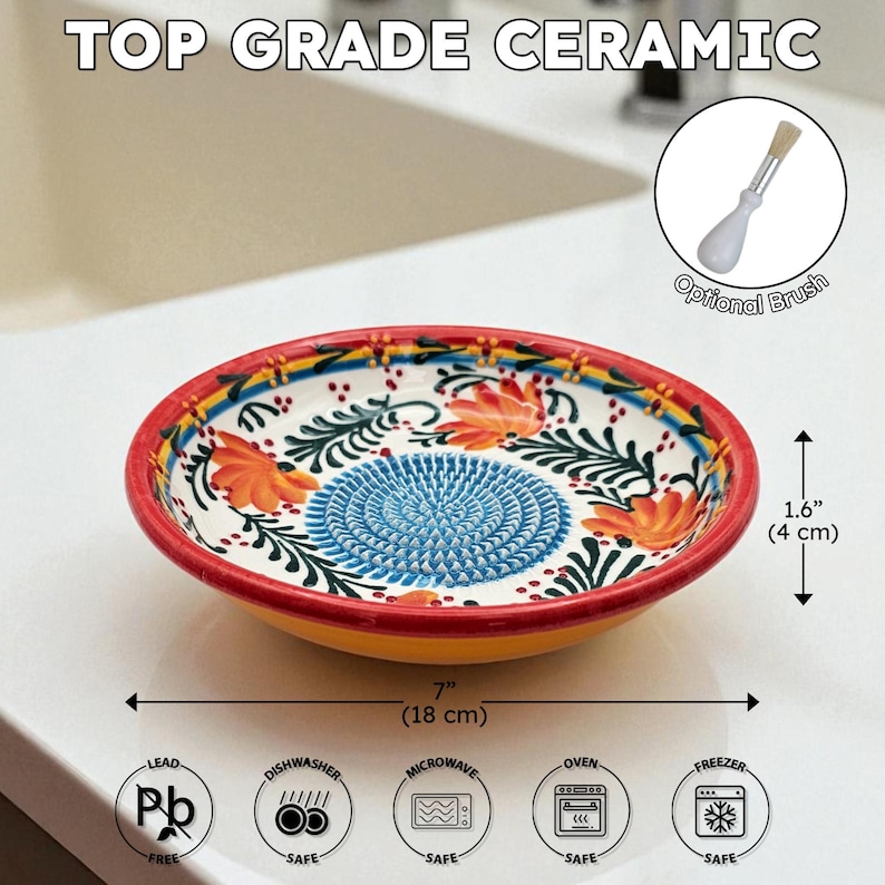 May include: A ceramic grater bowl with a vibrant floral design. The bowl is 7 inches (18 cm) in diameter and 1.6 inches (4 cm) high. It features a blue grating surface, orange flowers, and a red rim. Includes an optional brush.