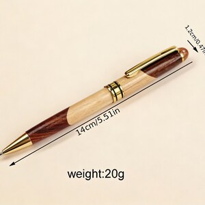 May include: A wooden pen with a gold-colored clip and tip. The pen is 5.51 inches long and weighs 20 grams. The pen's design incorporates light and dark wood sections. The pen's cap is 0.47 inches long.