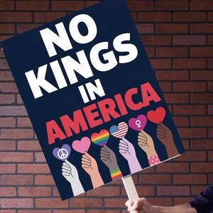 Puede incluir: Un letrero azul marino con las palabras "NO KINGS IN AMERICA" en blanco y rojo. El letrero presenta manos sosteniendo s&iacute;mbolos en forma de coraz&oacute;n con varios dise&ntilde;os, incluyendo un signo de paz, un arco&iacute;ris y la bandera estadounidense.