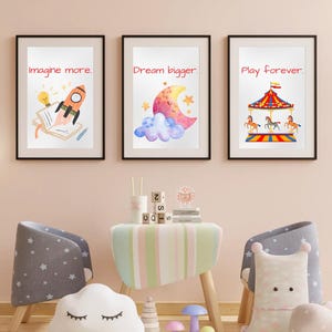 Puede incluir: Tres impresiones artísticas enmarcadas con citas inspiradoras: "Imagina más", "Sueña más grande" y "Juega para siempre". Las impresiones presentan un cohete, una luna y un carrusel. La habitación incluye muebles y objetos decorativos para niños.