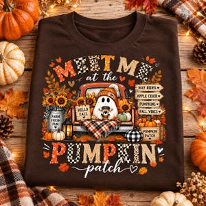 Peut inclure: Un t-shirt marron foncé avec une impression graphique représentant un fantôme assis dans un camion entouré de tournesols, de citrouilles et de feuillages d'automne. Le texte indique "MEET ME at the PUMPKIN patch" avec des panneaux "HAY RIDES", "APPLE CIDER", "PUMPKINS" et "FALL VIBES".