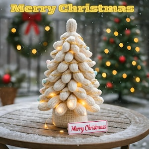 Könnte beinhalten: Ein handgefertigter, cremefarbener Weihnachtsbaum aus Strick mit warmweißen Lichtern und kleinen Pastellfarbenen Ornamenten. Der Baum steht auf einem Holztisch mit einem Schild mit der Aufschrift "Merry Christmas". Im Hintergrund ein Weihnachtskranz und ein geschmückter Weihnachtsbaum.