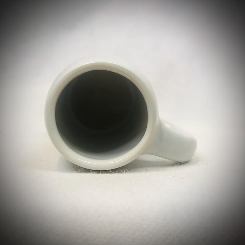 May include: A set of three ceramic mugs with a speckled, matte finish. The mugs are in shades of cream, light gray, and dark gray. Each mug has a simple, minimalist design, perfect for coffee or tea.