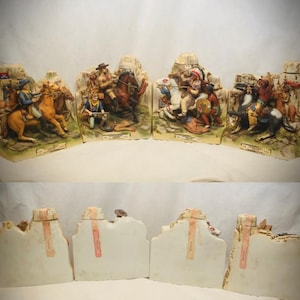 Peut inclure: Un ensemble de quatre carafes en céramique présentant des scènes de l'Ouest peintes à la main avec des personnages à cheval sur des paysages rocheux. Chaque pièce comprend un petit bouchon sur le dessus et une étiquette rectangulaire.