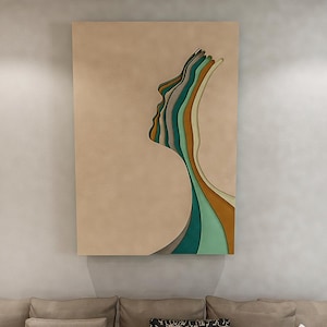 Puede incluir: Una obra de arte mural rectangular con un diseño de perfil en capas. La obra de arte muestra el perfil de una mujer con una serie de capas curvas y coloridas en tonos de verde, verde azulado y marrón sobre un fondo beige.