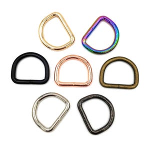 Puede incluir: Colección de siete anillas en D en varios acabados metálicos: oro, iridiscente, negro, oro rosa, latón antiguo, plata y metal de cañón. Estas anillas en forma de semicírculo se utilizan para la fabricación de bolsos y otros proyectos de artesanía.