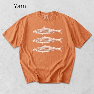 May include: Orange t-shirt with a white graphic of three fish. The word "Yam" is printed in the upper left corner. The shirt has short sleeves and a crew neck.