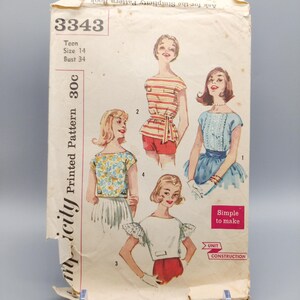 Può includere: Modello di cucito vintage Simplicity 3343 per una ragazza di taglia 14, circonferenza del seno 86 cm. Il modello include quattro stili diversi di top a maniche corte. Il modello è stampato su uno sfondo bianco con testo nero e illustrazioni dei top indossati da quattro modelle.