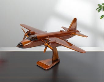 Könnte beinhalten: Ein Holzmodellflugzeug mit dunkelbraunem Finish. Das Modell verfügt über zwei Propeller, Flügel und ein Heck, montiert auf einem Holzständer. Das Flugzeugdesign umfasst ein detailliertes Cockpit und eine stromlinienförmige Form.