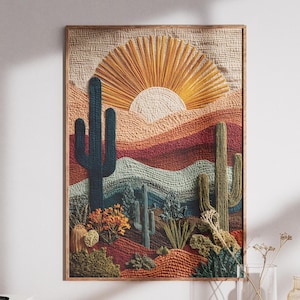 Può includere: Un'opera d'arte tessile incorniciata raffigurante un paesaggio desertico con cactus, montagne e un sole. L'opera d'arte utilizza una calda tavolozza di colori di arancioni, rossi e verdi, con un aspetto strutturato e tessuto. L'opera è esposta su un mobile in legno.