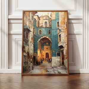 Può includere: Una stampa incorniciata raffigurante una scena di strada europea con un arco. L'opera presenta edifici nei toni del blu, beige e marrone, con figure che camminano per la strada. La cornice in legno contiene l'opera, esposta su un pavimento in legno.