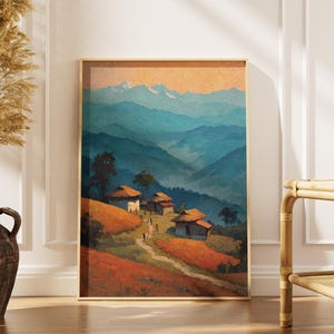 Puede incluir: Una impresión artística enmarcada que representa una escena de un pueblo de montaña. La obra de arte presenta una paleta de colores cálidos con tonos naranja, marrón y azul. La impresión muestra un pueblo en las montañas con un camino.