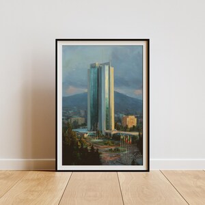 Può includere: Stampa artistica incorniciata di un edificio moderno e alto con facciata in vetro, sullo sfondo di montagne e cielo nuvoloso. L'opera presenta una tavolozza di blu, verdi e gialli, con bandiere in primo piano.