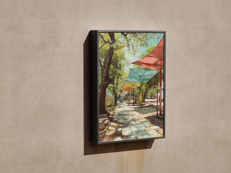 Puede incluir: Una pintura enmarcada representa una escena callejera soleada con toldos coloridos. La obra de arte muestra un camino adoquinado bordeado de &aacute;rboles y puestos de mercado, con toldos rojos, turquesas y amarillos. La pintura est&aacute; en un marco negro.