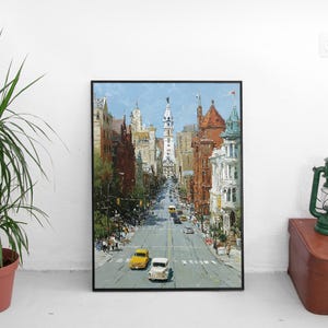 May include: An oil painting of a city street scene with buildings on either side and a tall white tower in the distance. The painting has a black frame and is displayed on a white wall. Two yellow cars and one white car are on the street.