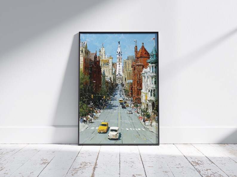 May include: An oil painting print of a city street scene, framed in black. The artwork depicts a wide avenue lined with buildings in shades of brown, red, and white. Two vintage cars, one yellow and one white, are in the foreground.