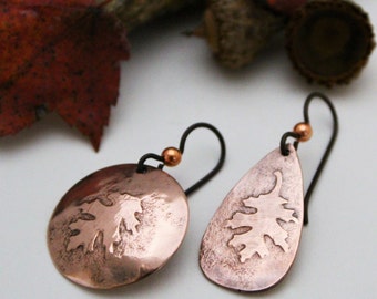 May include: A pair of copper earrings with a leaf design. The earrings are teardrop shaped and have a hammered finish.