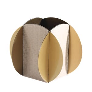 Op de afbeelding: Een decoratieve, bolvormige container met een uniek ontwerp. De container bestaat uit verschillende gebogen panelen in tinten beige, crème en goud. De panelen zijn zo gerangschikt dat ze een afgeronde vorm creëren, geschikt voor het vasthouden van kleine items.