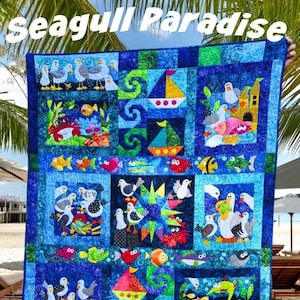 Könnte beinhalten: Eine farbenfrohe Quiltdecke mit einem Möwen-Motiv. Die Decke zeigt verschiedene Meeresbewohner, darunter Fische, Krabben und Möwen. Die Decke ist aus verschiedenen Stoffen gefertigt, darunter Blau, Grün und Gelb. Die Decke ist perfekt für ein Strandhaus oder ein nautisch gestaltetes Zimmer.