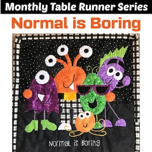 Może przedstawiać: Bieżnik stołowy w czarno-białą kratę z kolorowym wzorem potworów. Potwory są pomarańczowe, zielone, fioletowe i mają duże oczy. Na bieżniku wyszyty jest napis "Normal is Boring".