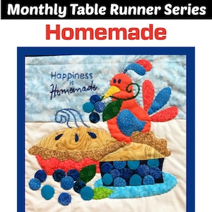 Puede incluir: Un camino de mesa azul y rojo con fondo blanco. El camino de mesa presenta un diseño de patchwork con una estrella en el centro y un corazón rojo. El camino de mesa también presenta un pájaro con una tarta y arándanos. El texto "Happiness is Homemade" está bordado en el camino de mesa.