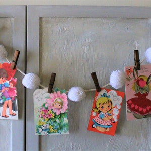 Valentijnsdagslinger met zes vintage kaarten bevestigd met vintage houten wasknijpers crèmewitte pomponslinger, Valentijnsdagdecoratie