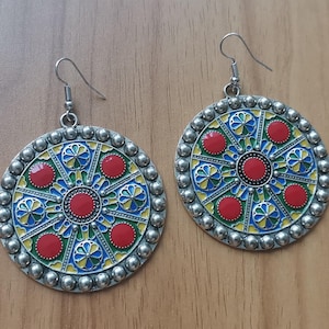 Round ethnic earrings in traditional Amazigh Kabyle colors hanging with Berber motifs in modern colors