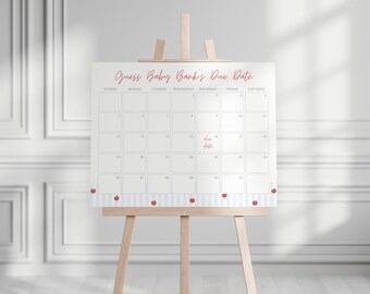 May include: A white calendar with the text "Guess Baby's Due Date" in red script is displayed on a wooden easel. The calendar has a blue and white striped border with red apple accents. The words "Due Date" are written in red.