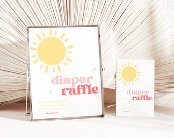 May include: A framed sign and a smaller card with a sun graphic and the words "diaper raffle" in pink and red. The sign includes text that reads "If you brought diapers for the raffle, please leave the diapers and enter here. Thank you."