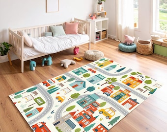 May include: A rectangular play rug featuring a town scene with roads, buildings, trees, and vehicles. The rug has a cream-colored background with gray roads, and colorful illustrations of a fire station, police station, and park. The rug is on a wooden floor.