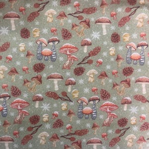 May include: A repeating pattern of mushrooms, pinecones, and snowflakes on a muted green background. The mushrooms vary in size and color, with red, brown, and white caps. The pinecones and snowflakes add to the wintery theme.