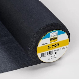 Könnte beinhalten: Eine Rolle dunkelmarineblauen Stoffes mit einem Etikett mit der Aufschrift "G 700". Das Etikett ist weiß, gelb und blau. Der Stoff ist 90 cm breit und 23 m lang.