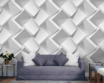 Peut inclure: Un salon moderne avec un canapé gris orné de coussins blancs et gris. Le mur derrière le canapé présente un motif géométrique 3D blanc et gris. Une petite table d'appoint avec une plante est à gauche.