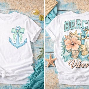 May include: White t-shirts with beach-themed designs. One shirt features a blue anchor with a bow, the other has the words "Beach Vibes" with an anchor, flowers, and seashells. Both shirts are short-sleeved.