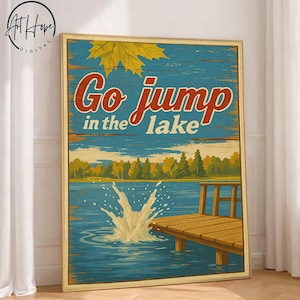 Puede incluir: Arte de pared enmarcado en madera con el texto "Go jump in the lake" en rojo y blanco. El arte presenta una escena de lago con un muelle de madera, árboles y un chapoteo en el agua. Una hoja amarilla está en la esquina superior izquierda.