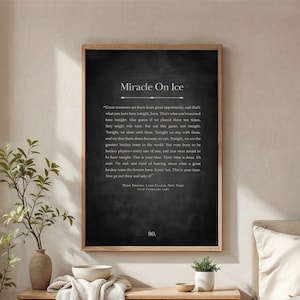 May include: A framed print with the text "Miracle On Ice" in white on a dark background. The print includes a quote about hockey and the date February 22nd, 1980. The frame is a light brown color.