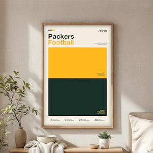 May include: A framed poster with a minimalist design featuring the words "Packers Football" in yellow and black. The poster has a yellow and dark green color block design. The poster also includes the number of championships and playoff appearances.