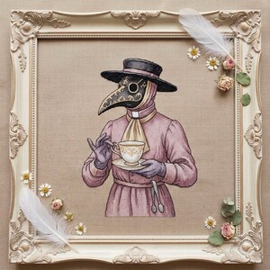 Könnte beinhalten: Eine Kreuzstichstickerei eines Pestarztes mit schwarzem Hut und malvenfarbenem Gewand, der eine weiß-goldene Teetasse hält. Das Kunstwerk befindet sich in einem verzierten cremefarbenen Rahmen, der mit weißen Federn, Gänseblümchen und Rosen geschmückt ist.