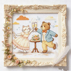 Könnte beinhalten: Kreuzstich-Kunstwerk in einem cremefarbenen, verzierten Rahmen. Das Bild zeigt eine Katze und einen Bären, die mit Champagnergläsern anstoßen. Die Katze trägt ein Kleid, und der Bär trägt einen Anzug. Ein kleiner Tisch hält Blumen.