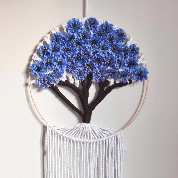 The 'Tree of Life' motif in blue cornflower with an Estonian cultural angle gives this genuine folk-art identity — not just another fringe wall piece.