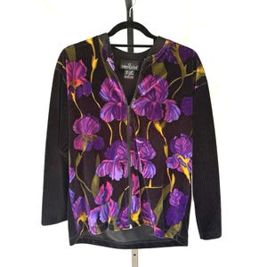 May include: A white ceramic mug with a black handle and the text "But First, Coffee" in a black, bold font. The mug is sitting on a white surface. The mug appears to be 12 ounces.