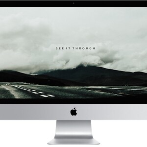 May include: A desktop computer with a black screen displaying a scenic image of a road leading to a mountain range with the text "SEE IT THROUGH" on the screen.