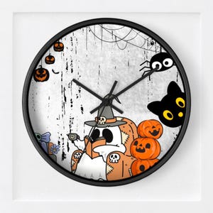 Puede incluir: Un reloj de pared redondo negro con temática de Halloween. La esfera del reloj presenta un fantasma de dibujos animados leyendo un libro, rodeado de calabazas, un gato negro y una araña. El fondo es blanco con vetas negras y una telaraña.