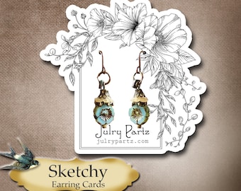 Peut inclure: Une carte blanche avec un motif floral noir et blanc. La carte a deux boucles d'oreilles turquoise et dorées qui pendent. La carte porte également le texte "Julry Partz" et "julrypartz.com". En dessous de la carte se trouve une pancarte dorée qui dit "Sketchy Earring Cards".