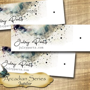 May include: Three white rectangular tags with a watercolor background featuring a blue and gray splatter design. The tags have the text "Julry Parts" and "julrypartz.com" printed on them. The bottom tag also has the text "Arcadian Series Jupiter" printed on it.
