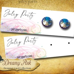 May include: A pair of iridescent blue stud earrings on a white card with the text "Julry Partz" and "julrypartz.com". The card has a pink and gold watercolor background with the text "Dreamy Pink Designer Card Collection".