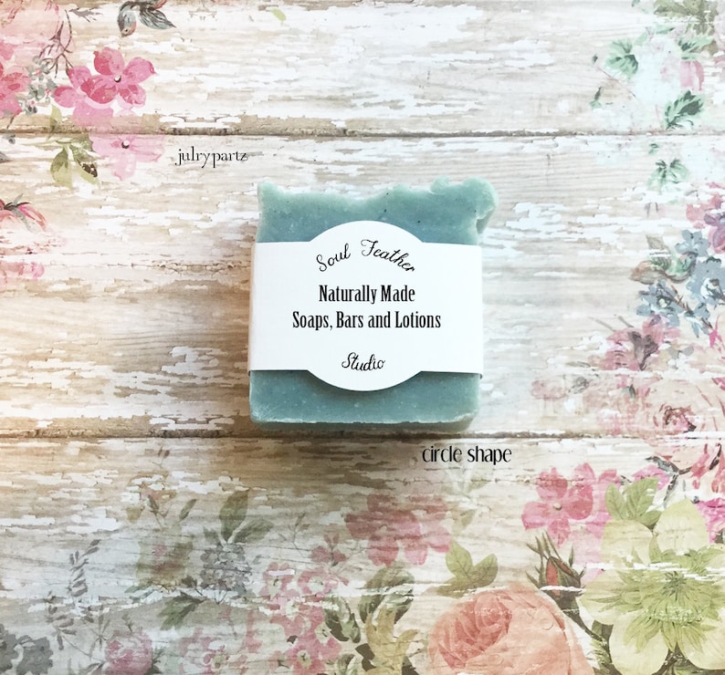 Puede incluir: Una barra de jab&oacute;n verde azulado con una etiqueta blanca que dice "Soul Teather Naturally Made Soaps, Bars and Lotions Studio" sobre un fondo con estampado floral.